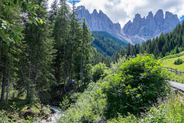 Fototapeta na wymiar Paisaje con bosques y montañas en el valle de Funes en la región de Sudtirol, Italia
