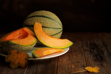 autumn still life with melon in a dark key on a wooden background
