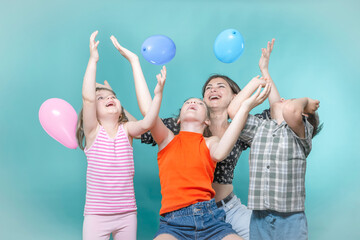 Children's holiday, mom and children have fun playing with inflatable colorful balls