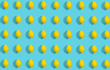 Fresh yellow lemon and a candy gummy lemon sweet on a bright blue background with copy space with sharp shadows. Healthy diet eating vs junk food concept. Raw food idea.