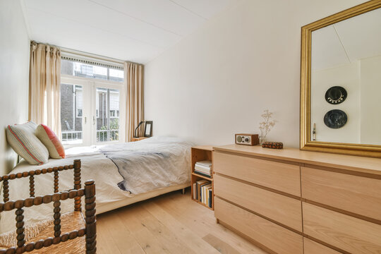 Light bedroom interior with wooden furniture and floor