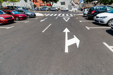 Car parking with traffic signs on the pavement