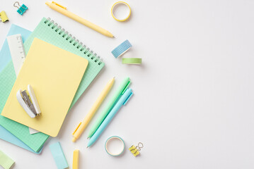 School supplies concept. Top view photo of stationery copybooks pens stapler ruler binder clips adhesive tape and erasers on isolated white background