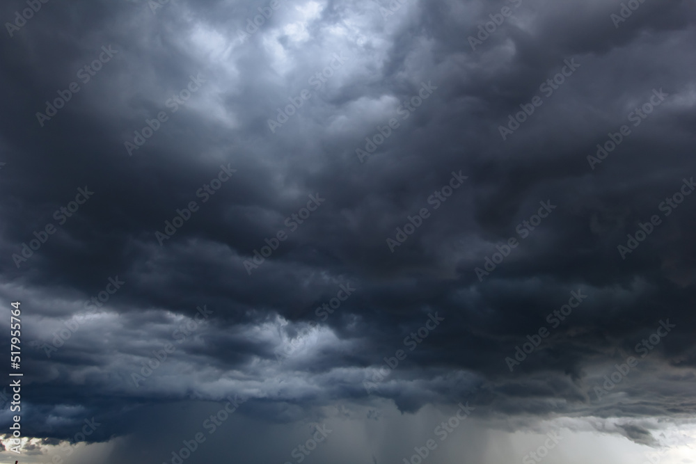 Wall mural The dark sky with heavy clouds converging and a violent storm before the rain.Bad or moody weather sky.