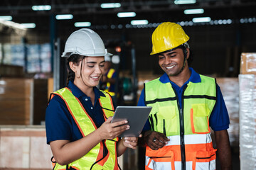 Warehouse workers checking details work on a tablet in the background warehouse., Industrial and...