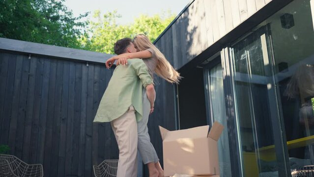 Cheerful young couple celebrating moving in their new tiny house in woods. Conception of moving and sustainable living.