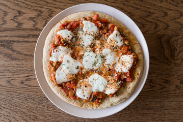 Cauliflower dough based pizza with mozzarella, tomato spread and seasoning 
