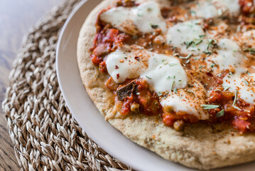 Cauliflower dough based pizza with mozzarella, tomato spread and seasoning 