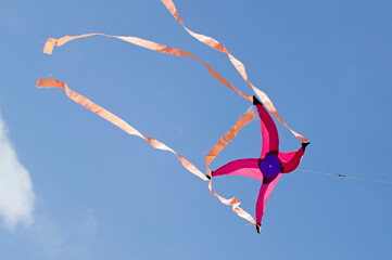 kite in the shape of a star flying in the blue sky