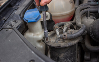 Car repair, fuel filter replacement.