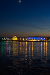 Fototapeta premium Night view of Nizhny Novgorod from the Volga River, a church, a bridge with a Russian city with illumination