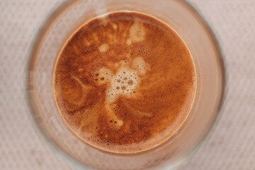 Close up top view of espresso coffee with beautiful crema in small glass.