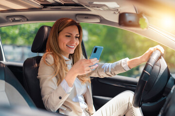 Businesswoman driver using a smart phone in car. Woman driver using a smart phone in car. Leisure, road trip, technology, travel and people concept