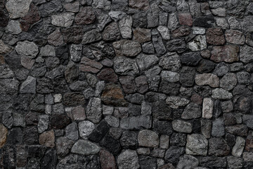 Charming view of wall with masonry of various stones. Background and texture of stone wall surface