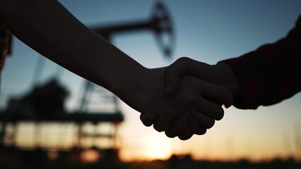 handshake oil contract. handshake a worker and businessman shaking hands against the backdrop of an...