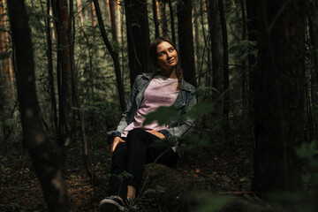 portrait of a beautiful girl in the forest in the rays of the sun breaking through the trees