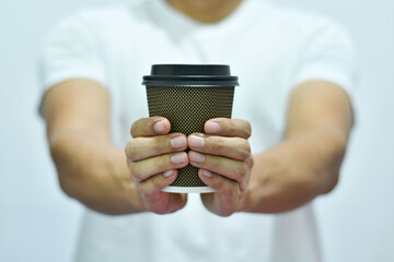 Hombre Moreno sosteniendo un vaso de cafe con las manos.