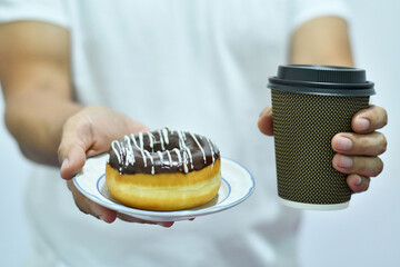 Hombre Moreno con una dona y cafe en las manos.