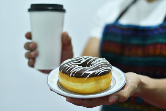 Mesero sirviendo Cafe y una Dona.