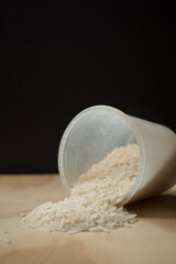 Some white raice grains spiled on a wooden table 