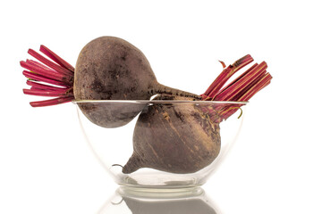 Two sweet red beets in a glass plate, close-up, on a white background.