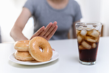 Dieting or good health concept. Young woman rejecting Junk food or unhealthy food such donut sweets...
