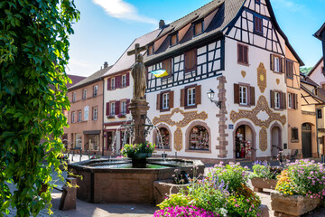 Place avec fontaine et maisons médiévales traditionnelles en Alsace