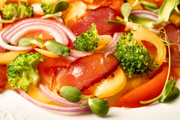 Salad with Prosciutto, tomatoes, onion, sweet pepper and broccoli. Cold snacks. Top view. Close up