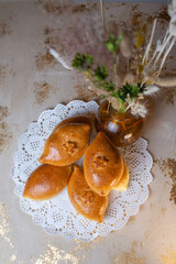 pies with potatoes on a white openwork napkin top view