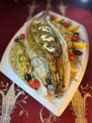 whole fish baked pike perch on a white plate top view
