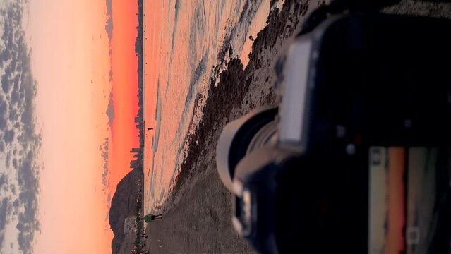  Video of a camera on a tripod taking pictures at sunrise on the beach, because it is the photography day.