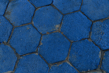 Top view on texture of hexagonal paving slabs covered with blue paint. Pavement tile pattern.
