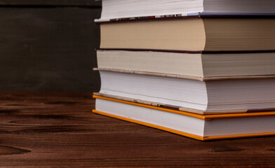 Close-up stack of books on a wooden table with space for text. Books in the library on the table....