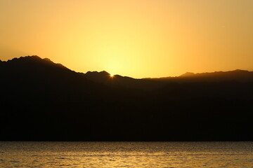 Sunrise at the Dead Sea in Israel. The sun comes out from behind the mountains in Jordan.
