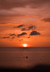 Persona pescando en el mar durante hermoso atardecer