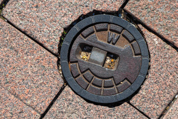 Street cap for municipal water supply with paving stones on a sidewalk in germany
