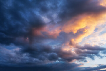 Naklejka na ściany i meble Background of a beautiful cloudy sky at sunset in twilight.