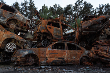 Fototapeta na wymiar A dump of shot and burned cars as a result of the Russian invasion of Ukraine. War in Ukraine.