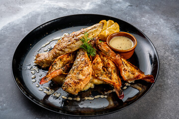 seafood bonanza with dip served in a dish isolated on dark background side view food