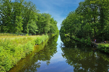 Eindhoven, Netherlands - July 17. 2022: Beautiful dutch water canal (Eindhovensche Kanaal) through green forest, cycling bike path