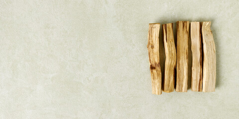 Holy wood (Palo santo) incense in row on green banner background with copy space.