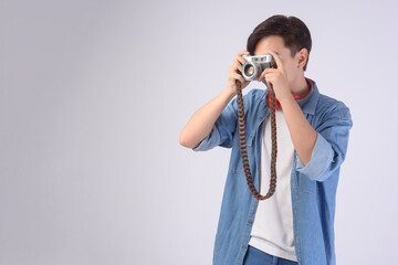 Young happy asian tourist man over white background studio, travel and holidays concept.