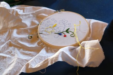 A close-up of a white cloth with a Kashubian embroidery on the hoop. - obrazy, fototapety, plakaty