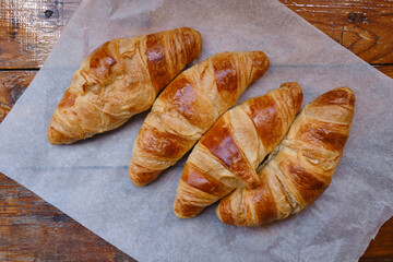 Ready crispy croissant on parchment paper. Fresh homemade cakes. Delicious traditional french crispy croissants for breakfast