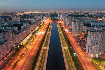 Fototapeta na wymiar Illuminated street in large city at night aerial panoramic view