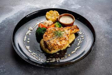 pan seared salmon served in a dish isolated on dark background side view food