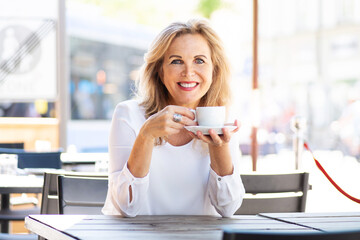 Sympathisch lächelnde Frau im reifen alter in einem Cafe