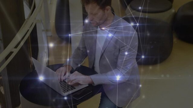Glowing network of connections over thoughtful caucasian businessman using a laptop at office