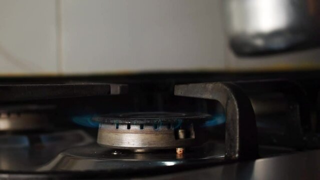 Hand lighting the stove withm an electric lighter
