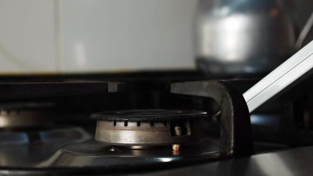 Hand lighting the stove withm an electric lighter